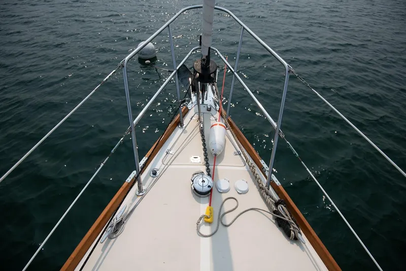 Slide: The Image of Bow of 2002 Tartan 4100 sailboat on calm water, featuring deck and railing. - 27