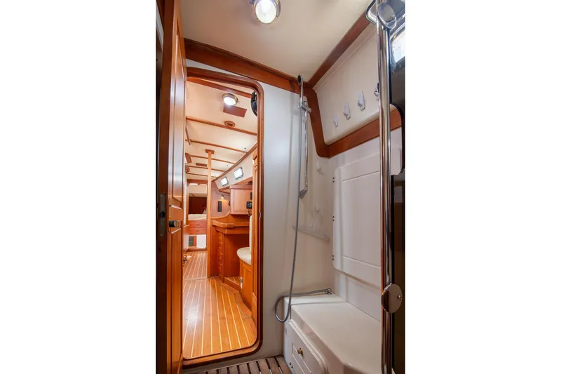 Slide: The Image of Interior of 2002 Tartan 4100 yacht, featuring a wooden cabin and shower area. - 38
