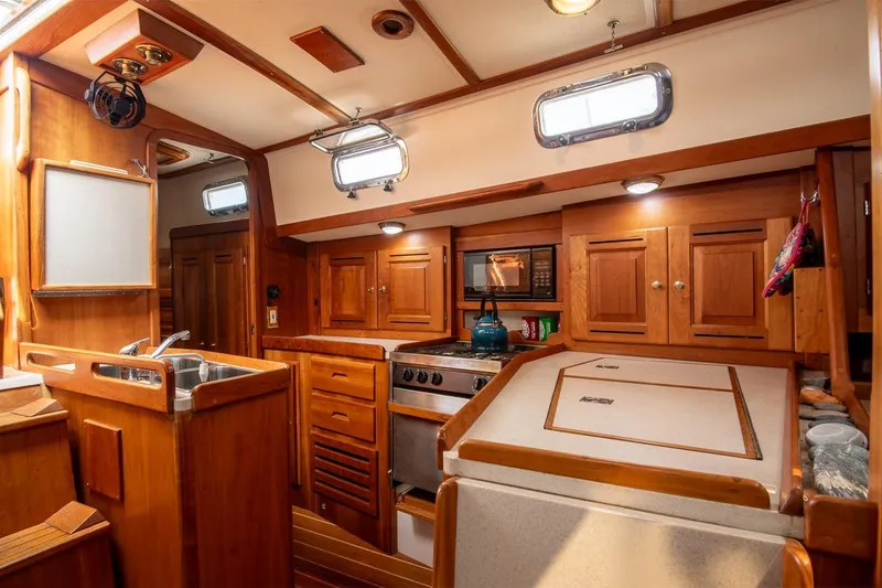 Slide: The Image of Cozy wooden interior of 2002 Tartan 4100 sailboat kitchen with stove and sink. - 40