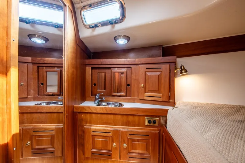 Slide: The Image of Luxurious 2002 Tartan 4100 yacht interior with wooden cabinetry and cozy sleeping area. - 53