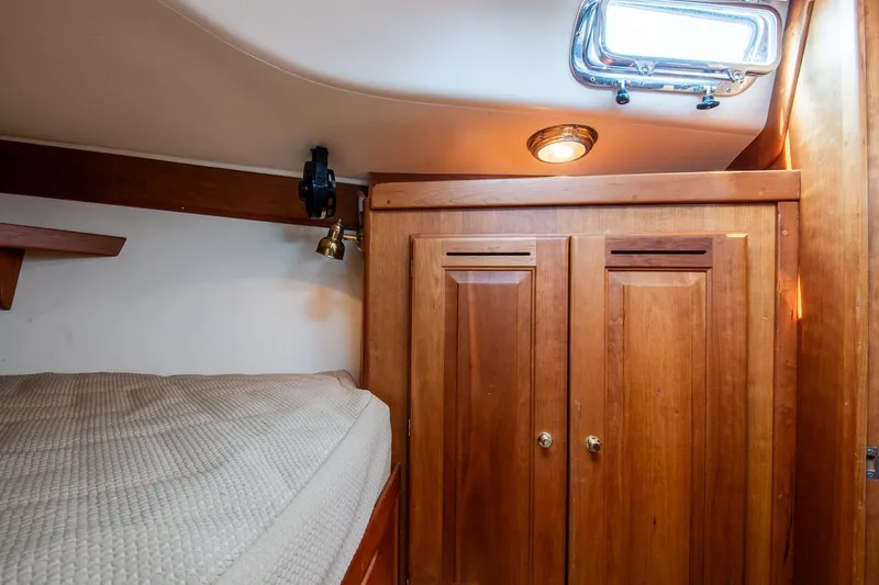 Slide: The Image of Cozy cabin interior of 2002 Tartan 4100 sailboat with wooden cabinetry and bedding. - 54