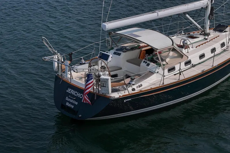 Slide: The Image of Sailboat Tartan 4100, 2002 model, anchored in calm waters with American flag. - 6