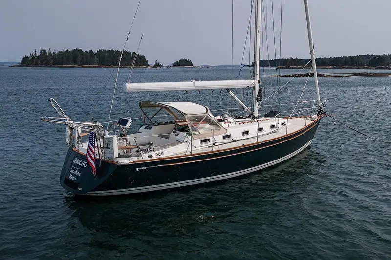 Slide: The Image of Sailboat Tartan 4100, 2002 model, anchored in calm waters with scenic island backdrop. - 8