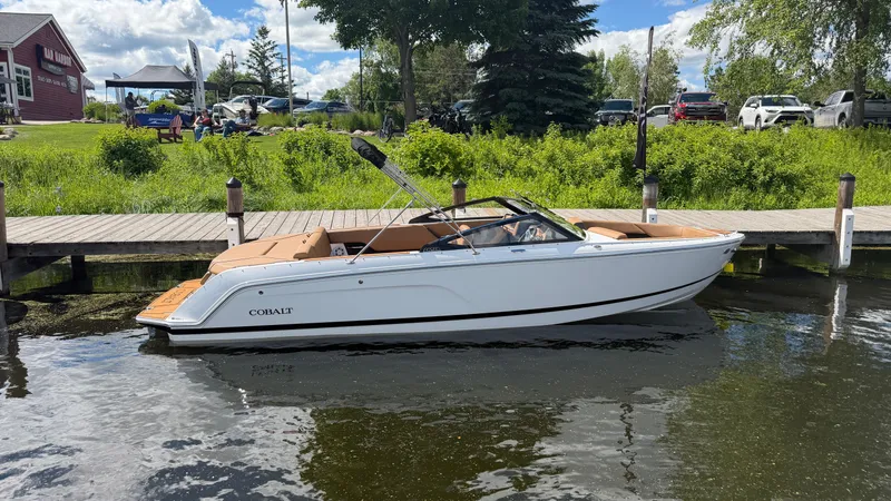 Slide: The Image of A sleek 2026 Cobalt CS23 boat docked at a tranquil pier. - 0