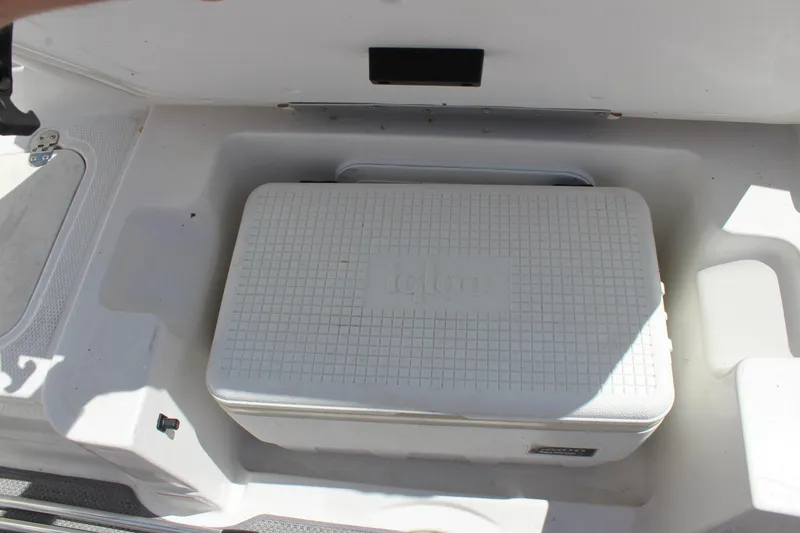 Slide: The Image of 2022 Tahoe 2150 boat storage compartment with Igloo cooler inside. - 13