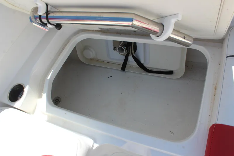 Slide: The Image of Open storage compartment in 2022 Tahoe 2150 boat, featuring stainless steel handle. - 14