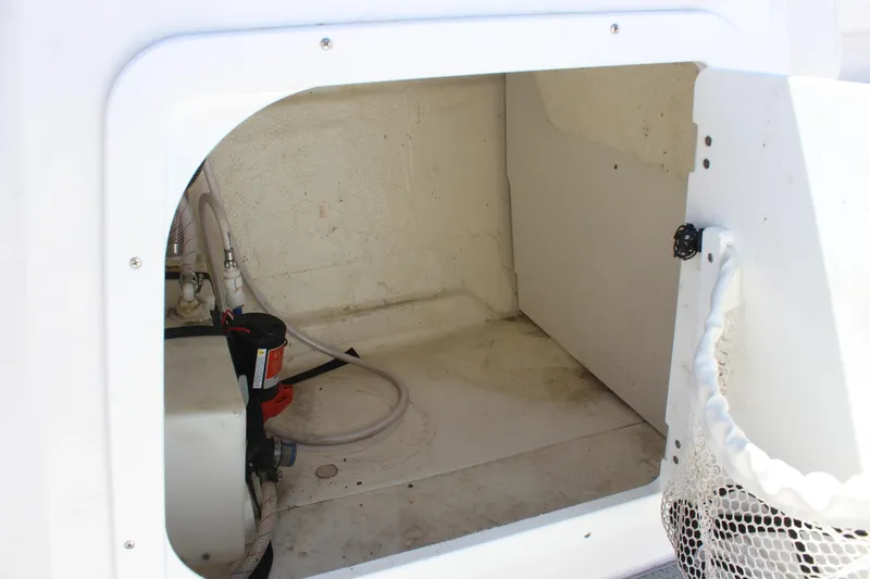 Slide: The Image of Storage compartment of a 2022 Tahoe 2150 boat, featuring hoses and equipment. - 16