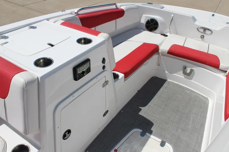 Slide: The Image of 2022 Tahoe 2150 boat interior with red and white seating, cup holders, and control panel. - 17