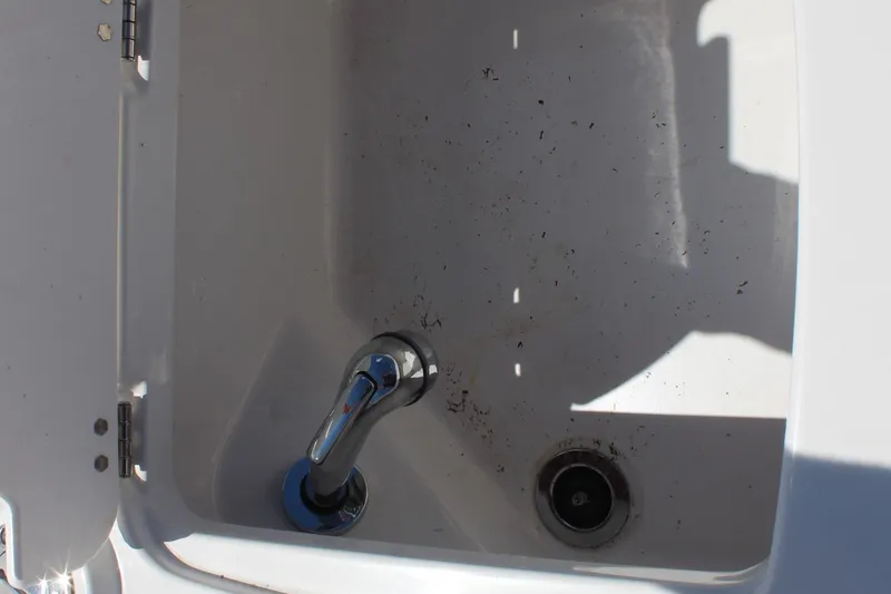 Slide: The Image of Dirty sink with faucet in 2022 Tahoe 2150 boat, showing debris and shadow. - 18