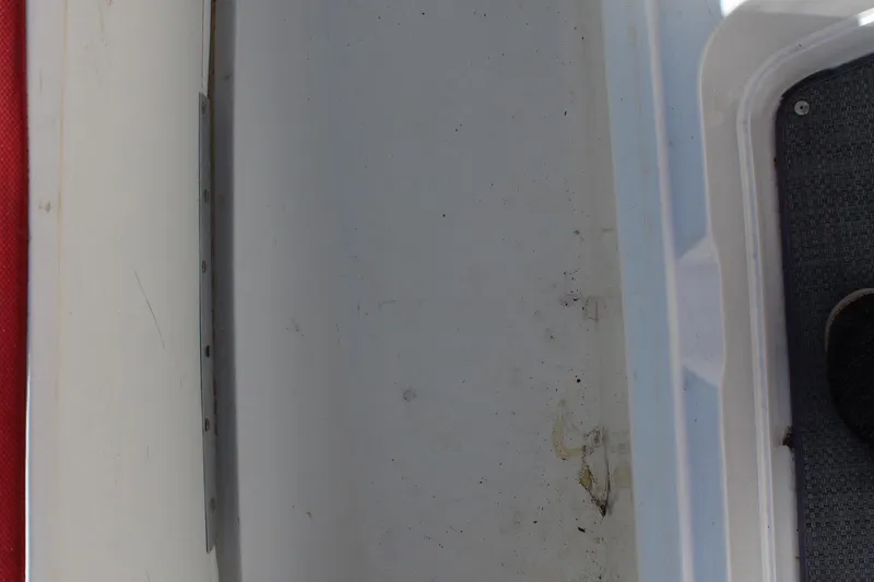 Slide: The Image of 2022 Tahoe 2150 boat interior with white and gray surfaces, showing wear and dirt. - 20