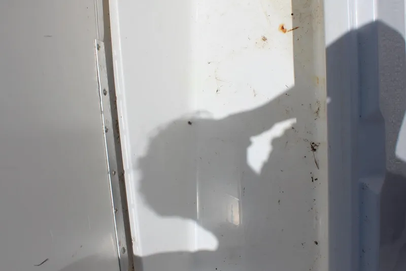 Slide: The Image of Shadow on white surface of 2022 Tahoe 2150 boat, showing dirt and marks. - 21