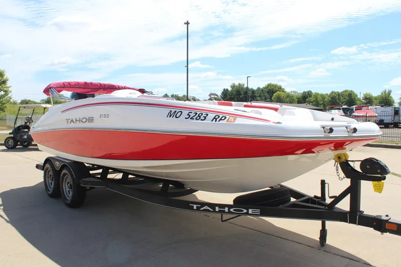Slide: The Image of 2022 Tahoe 2150 boat on trailer, red and white design, parked outdoors. - 3