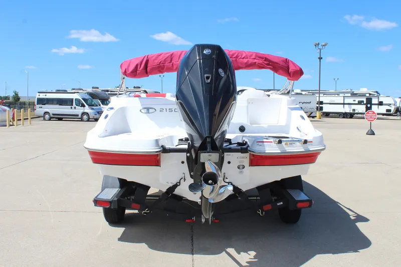 Slide: The Image of 2022 Tahoe 2150 boat with outboard motor, parked on concrete under clear blue sky. - 6