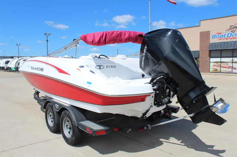 Slide: The Image of 2022 Tahoe 2150 boat with Mercury outboard motor on trailer, parked outdoors. - 7