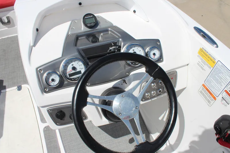 Slide: The Image of 2022 Tahoe 2150 boat dashboard with steering wheel and gauges in a sleek design. - 9