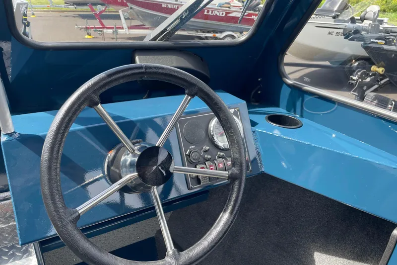 Slide: The Image of Steering wheel and dashboard of 2026 Hewescraft 200 ProV boat, featuring modern controls. - 17