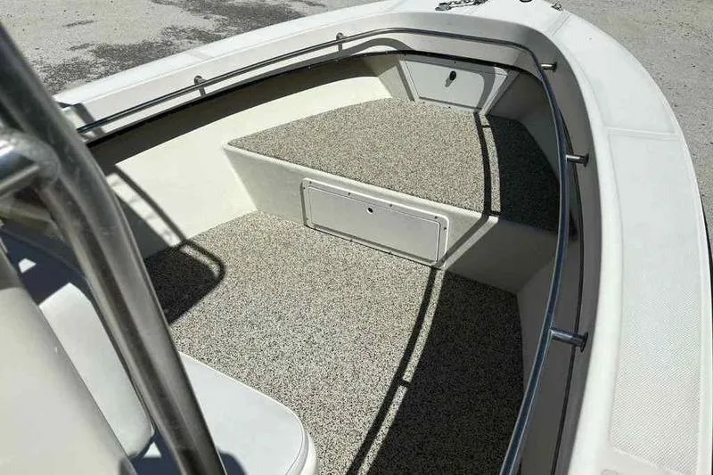 Slide: The Image of 2001 May-Craft 2300 CC boat interior with textured flooring and storage compartment. - 15