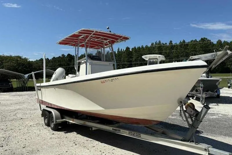 Slide: The Image of 2001 May-Craft 2300 CC boat on trailer, parked outdoors under clear sky. - 5