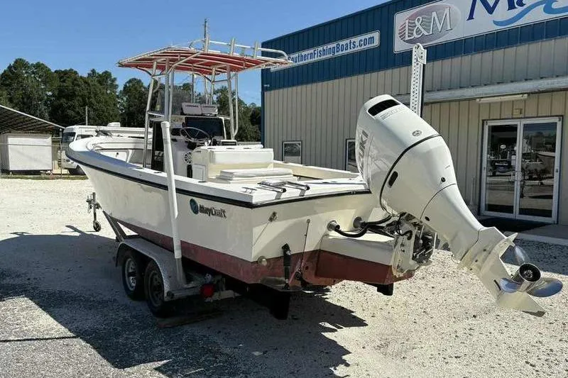 Slide: The Image of 2001 May-Craft 2300 CC boat with outboard motor on trailer, parked outside dealership. - 7