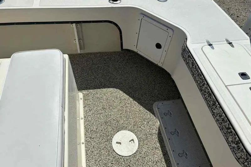 Slide: The Image of 2001 May-Craft 2300 CC boat interior with textured flooring and seating area. - 9