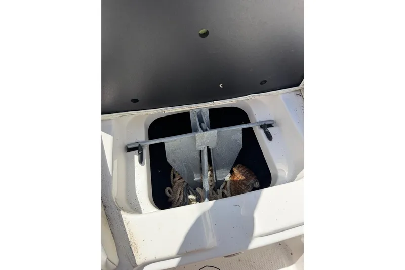 Slide: The Image of 2023 MasterCraft X24 boat anchor storage compartment with visible ropes and hardware. - 20