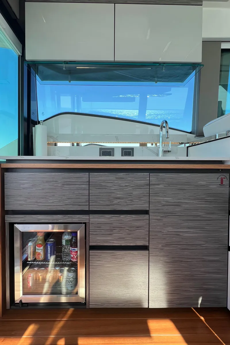 Slide: The Image of Modern kitchen area in 2021 Tiara Yachts C49 Coupe with mini fridge and sleek cabinetry. - 16