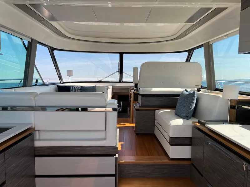 Slide: The Image of 2021 Tiara Yachts C49 Coupe interior with modern seating and panoramic windows. - 17