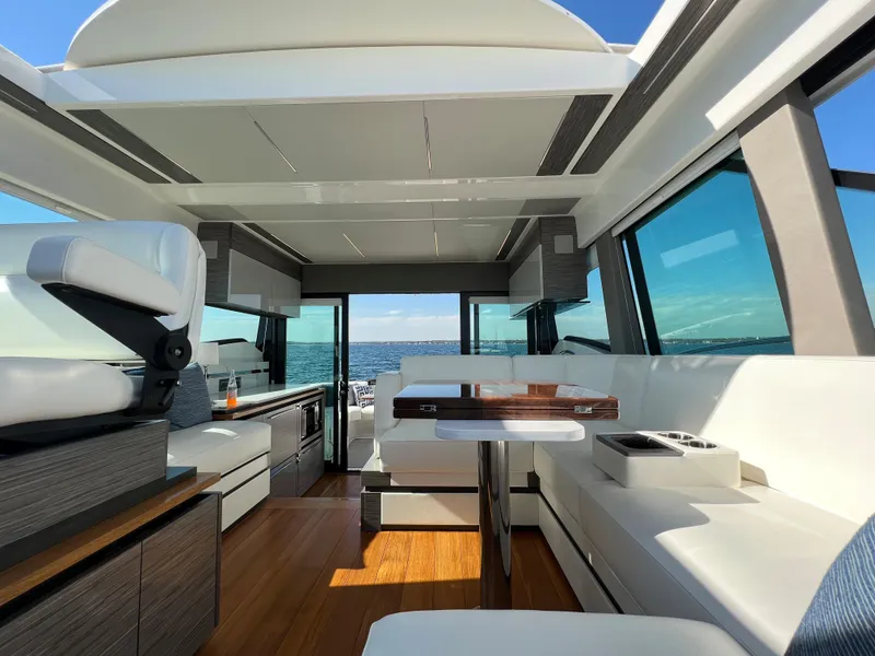 Slide: The Image of 2021 Tiara Yachts C49 Coupe interior with modern seating and ocean view. - 21