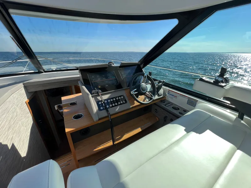 Slide: The Image of 2021 Tiara Yachts C49 Coupe helm with ocean view, featuring modern controls and luxurious seating. - 22
