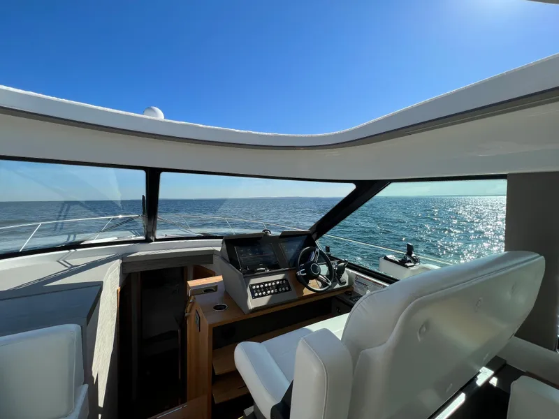 Slide: The Image of 2021 Tiara Yachts C49 Coupe interior with ocean view through panoramic windows. - 23