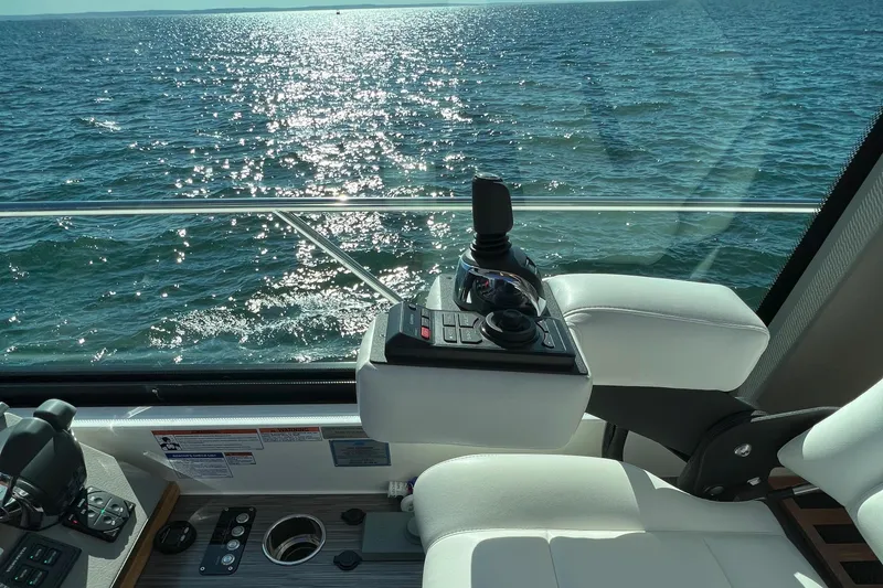 Slide: The Image of 2021 Tiara Yachts C49 Coupe helm with ocean view, featuring modern controls. - 25