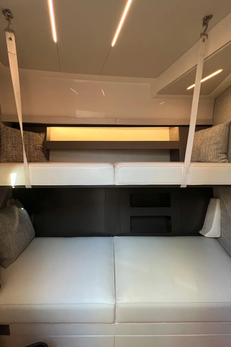Slide: The Image of Interior of 2021 Tiara Yachts C49 Coupe with modern bunk beds and ambient lighting. - 32