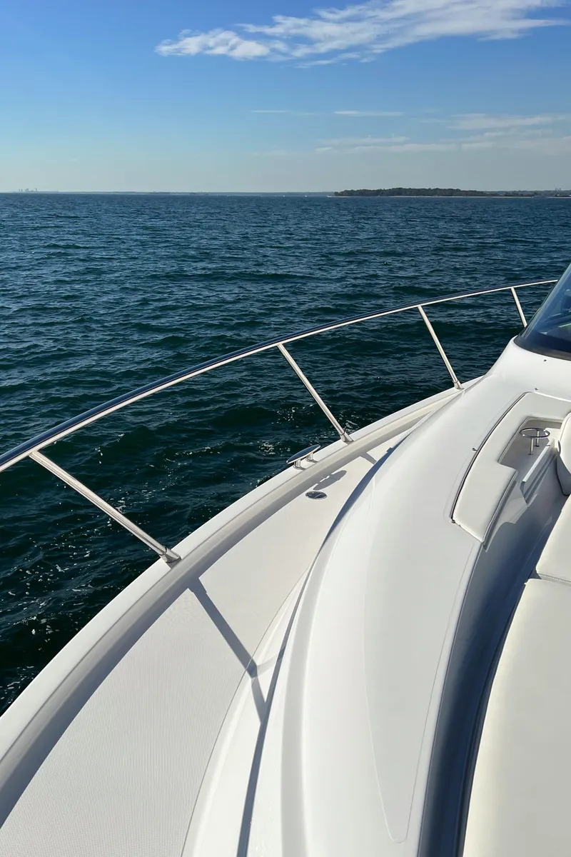 Slide: The Image of 2021 Tiara Yachts C49 Coupe cruising on open water under clear skies. - 47