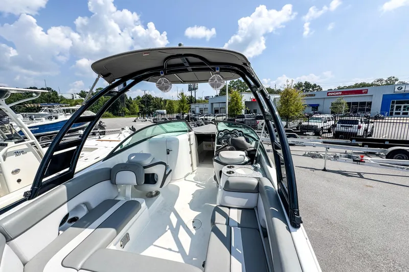Slide: The Image of 2022 NauticStar 243 DC boat interior with seating, speakers, and canopy under a sunny sky. - 3
