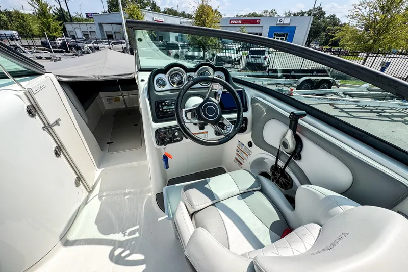 Slide: The Image of 2022 NauticStar 243 DC boat interior with steering wheel and dashboard controls. - 8