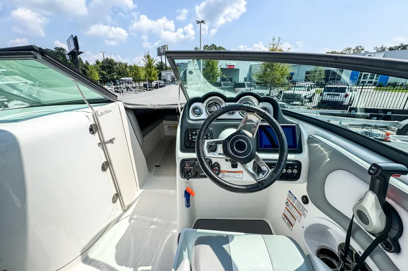 Slide: The Image of 2022 NauticStar 243 DC boat cockpit with steering wheel and dashboard controls. - 9