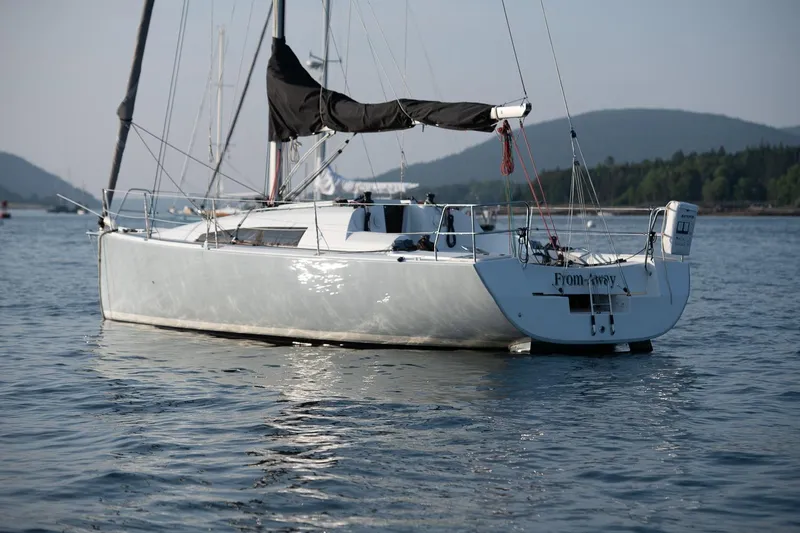 Slide: The Image of 2017 Jeanneau SunFast 3200 sailboat on calm water, scenic mountain backdrop. - 2