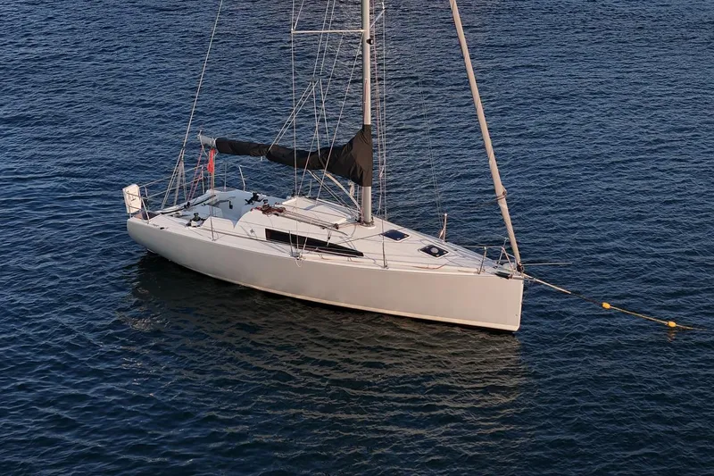 Slide: The Image of 2017 Jeanneau SunFast 3200 sailboat anchored on calm blue water. - 9