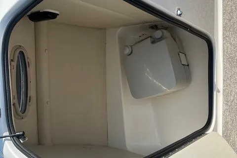 Slide: The Image of 2003 Chaparral Sunesta 222 boat interior storage compartment with window. - 14