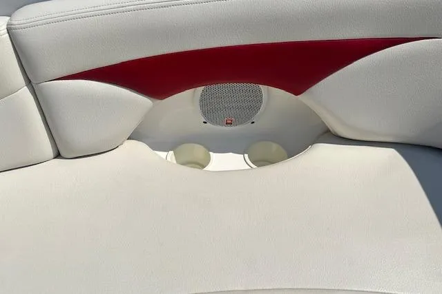 Slide: The Image of 2003 Chaparral Sunesta 222 boat interior with white and red upholstery, featuring cup holders and speaker. - 17