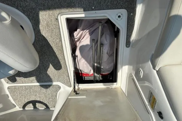 Slide: The Image of Storage compartment in a 2003 Chaparral Sunesta 222 boat, containing equipment and fabric. - 27