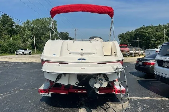 Slide: The Image of 2003 Chaparral Sunesta 222 boat with red canopy, parked on a trailer in a lot. - 4