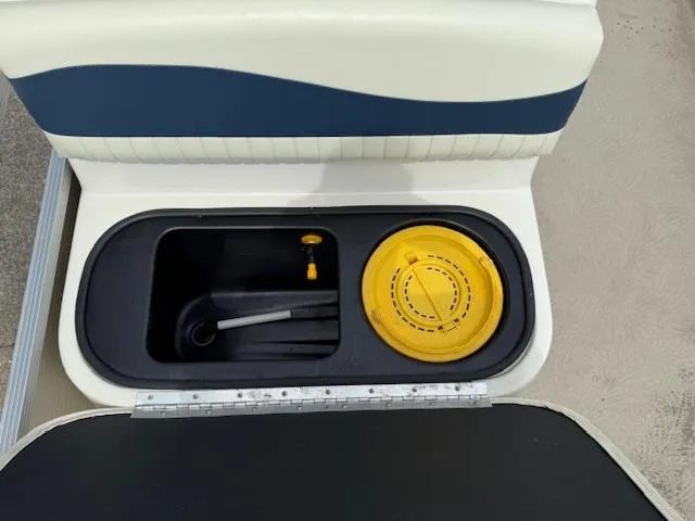 Slide: The Image of 2008 Bennington 2277FSi boat seat storage with yellow lid and measuring tool. - 13