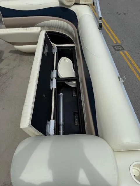 Slide: The Image of 2008 Bennington 2277FSi boat with open storage compartment on white seating. - 15