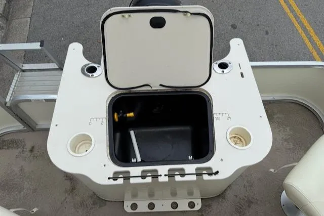 Slide: The Image of 2008 Bennington 2277FSi boat storage compartment with open lid and cup holders. - 21