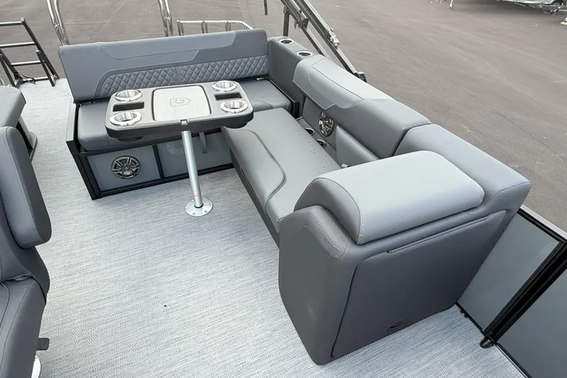 Slide: The Image of 2026 Godfrey SWEETWATER 2286 SFL boat interior with gray seating and table. - 16