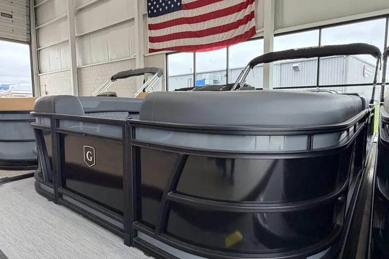 Slide: The Image of 2026 Godfrey Sweetwater 2286 SFL pontoon boat in showroom with American flag backdrop. - 25