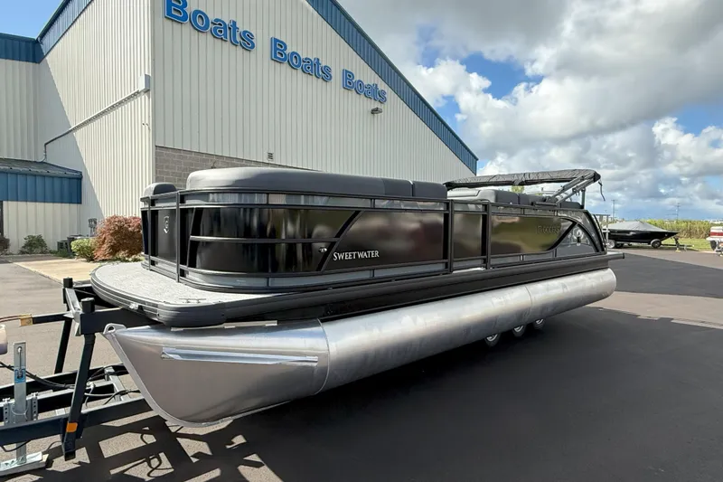 Slide: The Image of 2026 Godfrey SWEETWATER 2286 SFL pontoon boat parked outside a dealership under cloudy skies. - 4