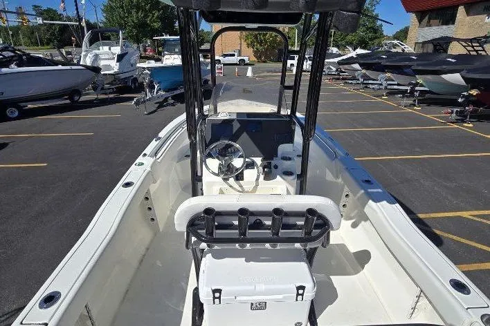 Slide: The Image of 2026 Key West 203 FS boat interior with steering console and seating in a parking lot. - 5