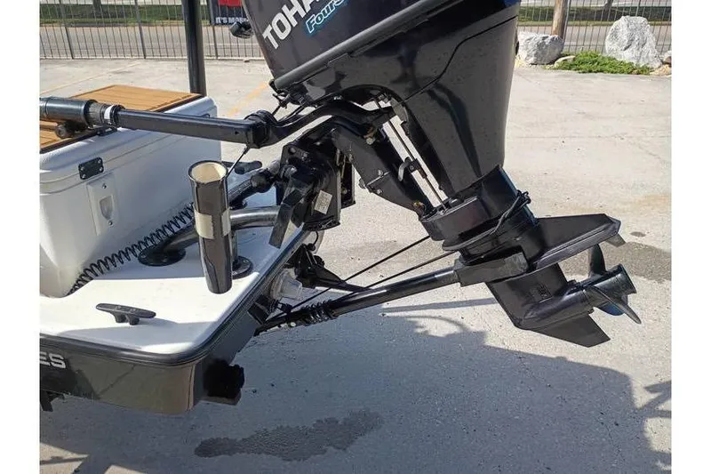 Slide: The Image of 2013 Pelican Ambush boat on trailer with motor and seating, parked outdoors. - 4